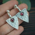 srebrne kolczyki trójkąty z roślinnym wzorem i fasetowanym granatem