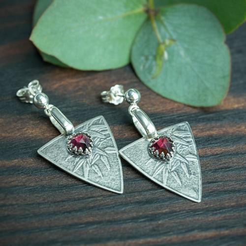 srebrne kolczyki trójkąty z roślinnym wzorem i fasetowanym granatem